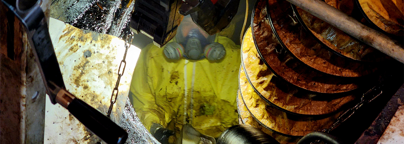 NEDT Technician in hazmat suit working in contaminated site.