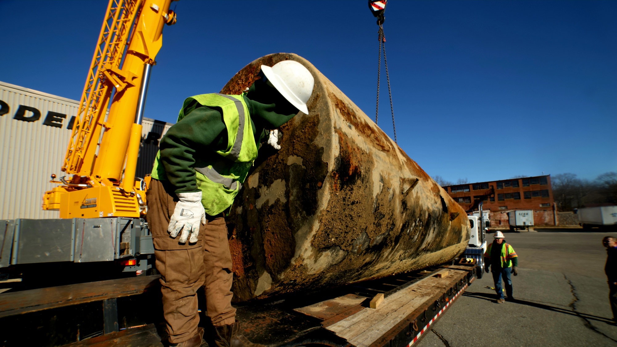 A team of NEDT staff prepare an underground storage tank for transportation after removal.